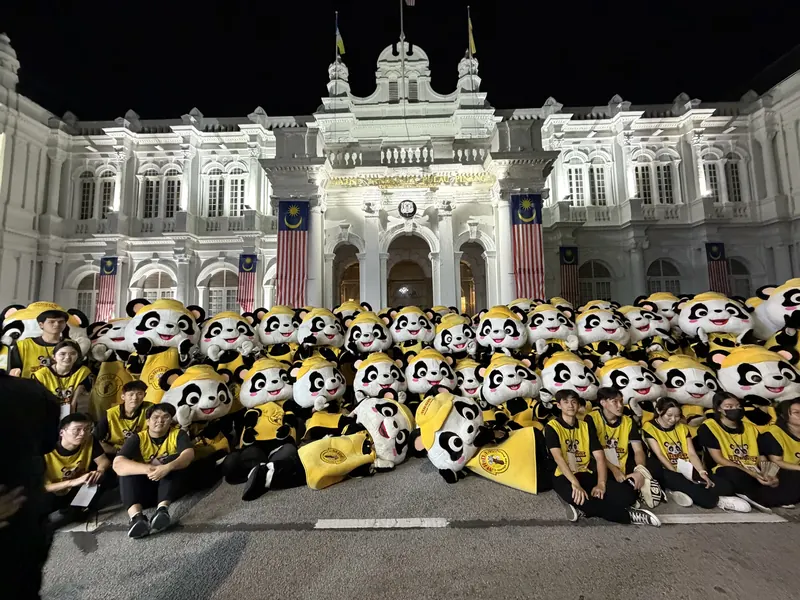 PANDAi mascots and crew together after dark in Penang, 15 August 2026