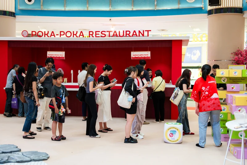 Visitors gathered at the POKA-POKA Restaurant counter while POKKA promoters assisted guests during the event.