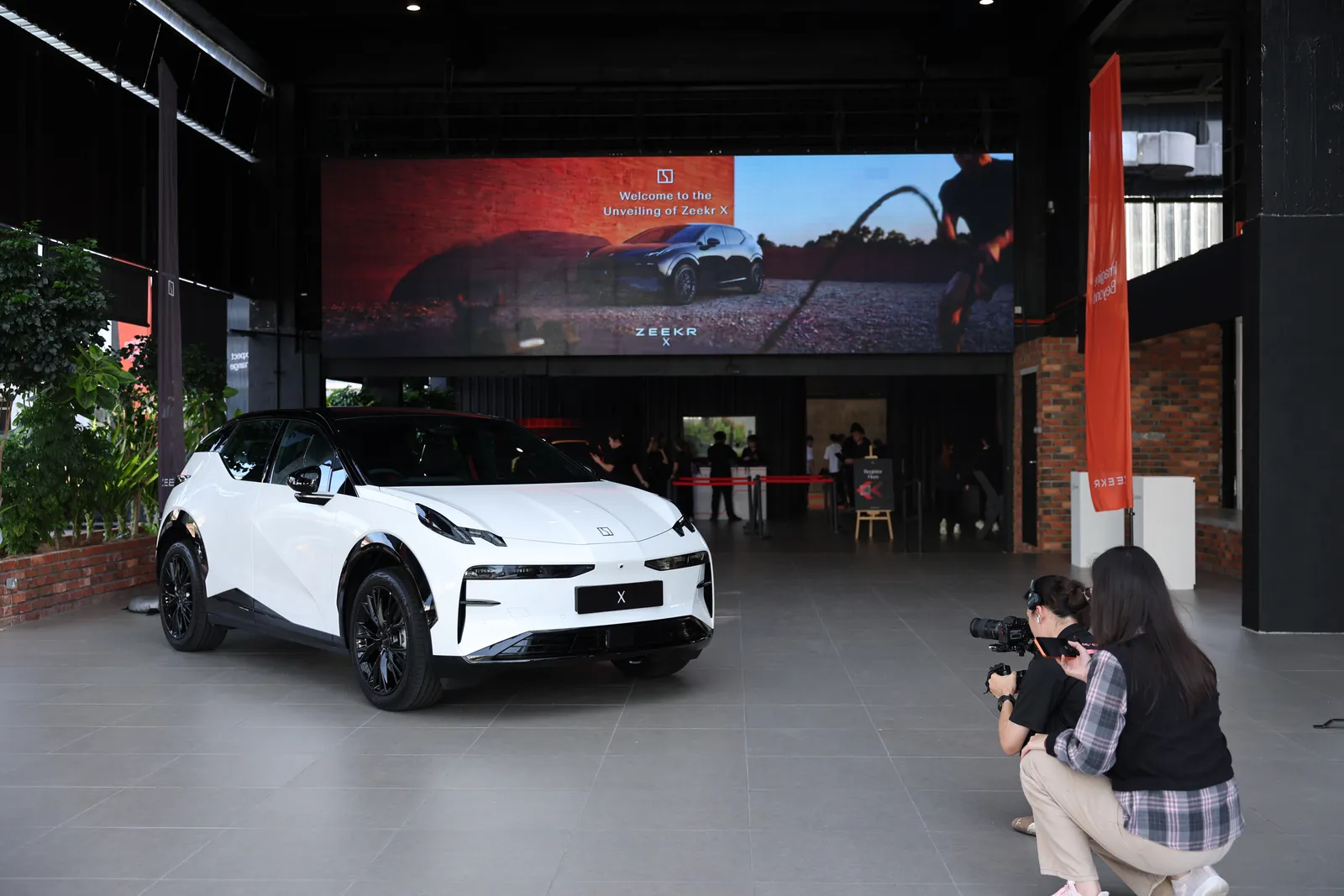 The ZEEKR X on display beneath the Welcome to the Unveiling of ZEEKR X entrance screen at Odeum, JioSpace, 23 June 2026.